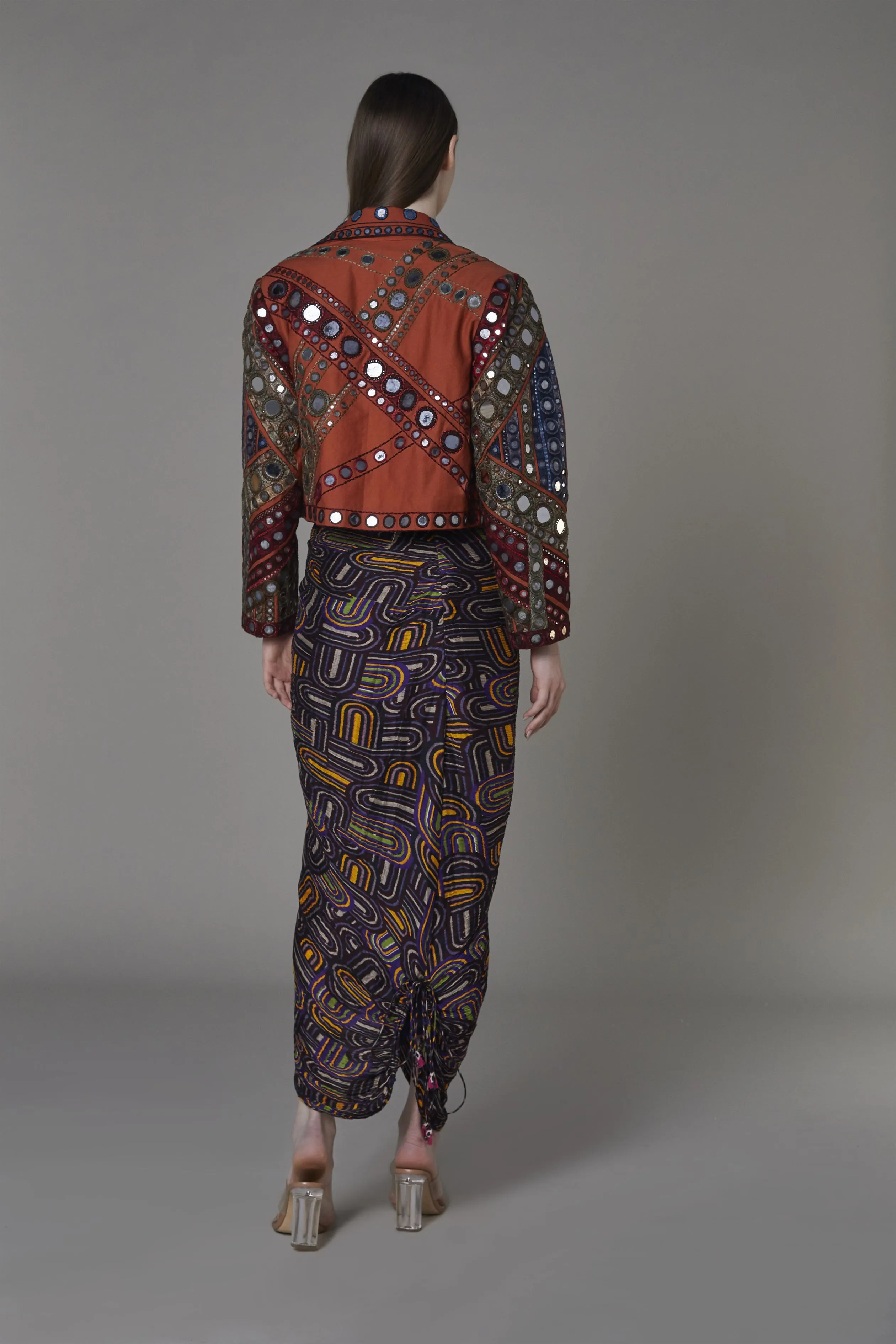 Saaksha & KinniÂ    I   Rust mirror embroidered jacket  Brown rust stripe bustier   Purple semi circle zipper beach skirt Jacket - Drill  Bustier - Satin  Skirt - Cotton Silk Jacket - Rust  Bustier - Rust  Skirt - Purple   SS22002    SS22111    SS22112